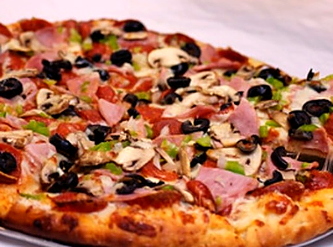 Round supreme pizza with ham, mushroom, olives and peppers